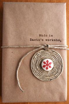 a package wrapped in twine with a red cross on it's front and the words made in santa's workshop