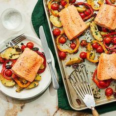 salmon and vegetables on a baking sheet with a spatula next to the pans