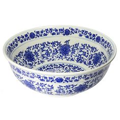 a blue and white bowl with floral designs on the rim, sitting in front of a white background