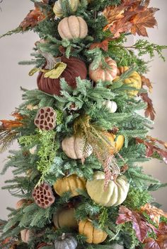 a christmas tree decorated with pumpkins, acorns and other autumn decorations is shown