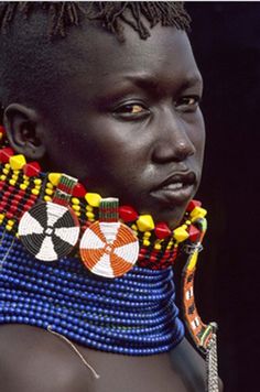 an african woman wearing beaded necklaces and earrings