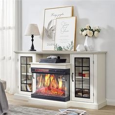 a living room with a fire place in the center and pictures on the wall above it