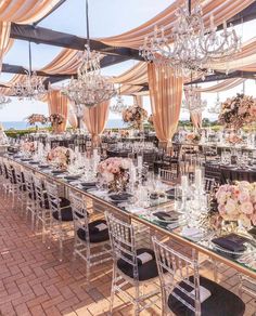 the tables are set up for a formal function with chandeliers and floral centerpieces