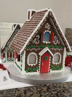 a gingerbread house decorated with icing and decorations on top of a kitchen counter