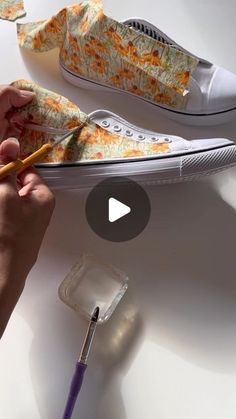 someone is painting their shoes with paintbrushes