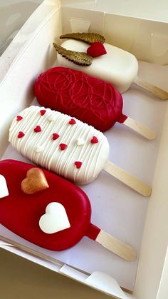 three heart shaped ice creams in a box with red and white icing on them