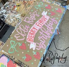 a birthday sign on top of a table next to a laptop and other art supplies