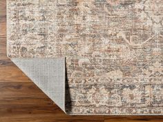 an area rug with wood flooring in the middle and a beige carpet on the other side