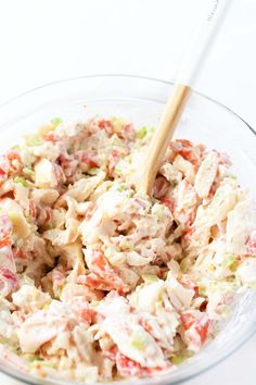 a bowl filled with coleslaw salad and a wooden spoon sitting in the bowl