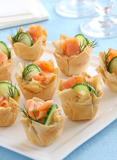 small appetizers with cucumbers, salmon and dill on a white plate