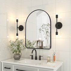 a bathroom sink with a mirror above it and lights on the wall next to it