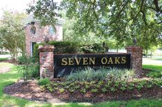 the sign for seven oaks is in front of a brick and stone entrance way