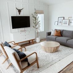 a living room filled with furniture and a flat screen tv mounted to the side of a wall