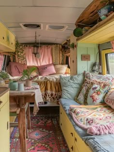 the inside of a camper with lots of pillows and blankets