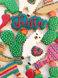 decorated cookies with the word fiesta written in large letters and cactuses on them, including an alpaca