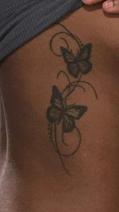 a woman's stomach with a butterfly tattoo on it