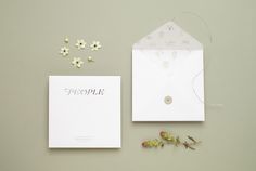 a white envelope and some flowers on a gray background with the word people written in silver