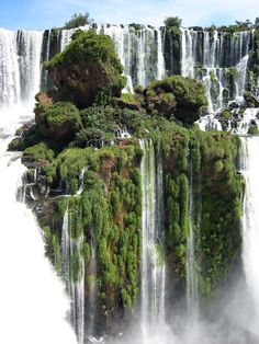 the waterfall is surrounded by trees and water