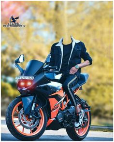 a man sitting on top of a motorcycle in front of some trees with orange rims