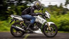 a man riding on the back of a white motorcycle