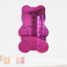 a pink teddy bear sitting in front of a window