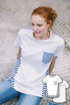 a woman sitting on the ground wearing a white t - shirt with blue striped pocket