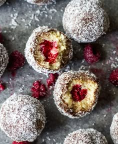 raspberry and powdered sugar doughnuts are arranged on a gray surface