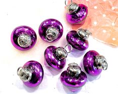 six purple glass ornaments with silver accents