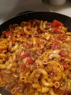 a skillet filled with macaroni and cheese on top of a stove