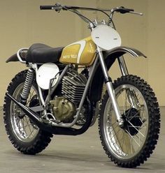 a yellow and white dirt bike parked in a garage