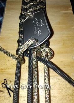 a black and silver belt with a tag on it's end, sitting on top of a wooden table