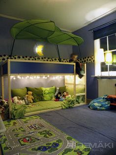 a child's bedroom with blue walls and green bedding, toys on the floor