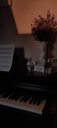 a vase with flowers on top of a piano