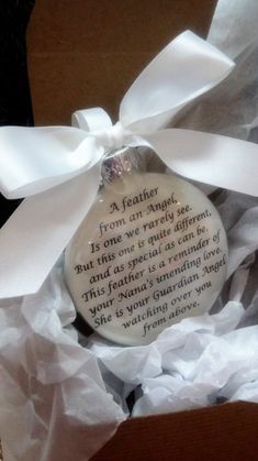 a ceramic ornament in a gift box with a white ribbon and poem on it