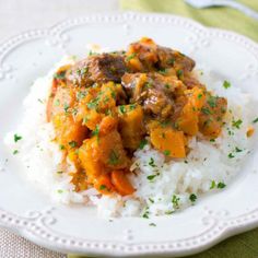 a white plate topped with rice and meat