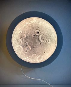 a plate with holes in the middle on a blue wall next to a light bulb