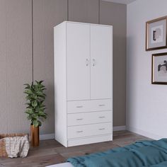 a white cabinet next to a bed with a plant in it and pictures on the wall