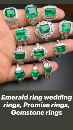 a person's hand holding seven emerald and diamond rings