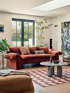 a living room filled with furniture and a large painting on the wall behind the couch