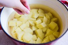 someone is adding sugar to potatoes in a pot