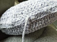 a close up view of the back of a chair covered in white yarn and fabric