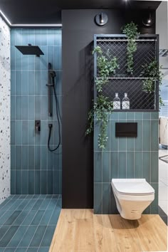 a modern bathroom with blue tiles and wood flooring on the walls, along with a white toilet