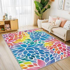 a colorful area rug in the middle of a living room with a teddy bear on the floor