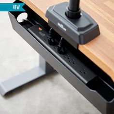 an electronic device is plugged into the side of a wooden table with metal legs