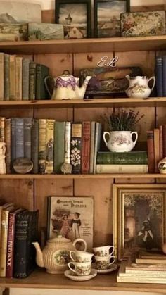 an old bookcase filled with books and tea cups