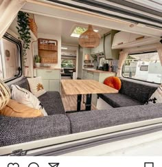 the inside of a camper with couches, tables and kitchen area in it