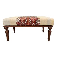 a wooden bench with a red and white cushion sitting on it's legs,