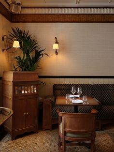 a table and chairs in a room with plants on the wall behind them, along with a couch