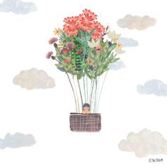 there is a flower pot with flowers in it on the ground and clouds behind it