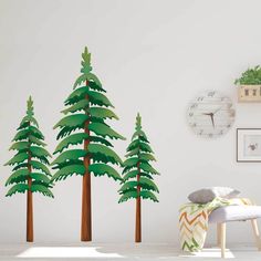 three paper trees in the corner of a room with a clock on the wall behind them